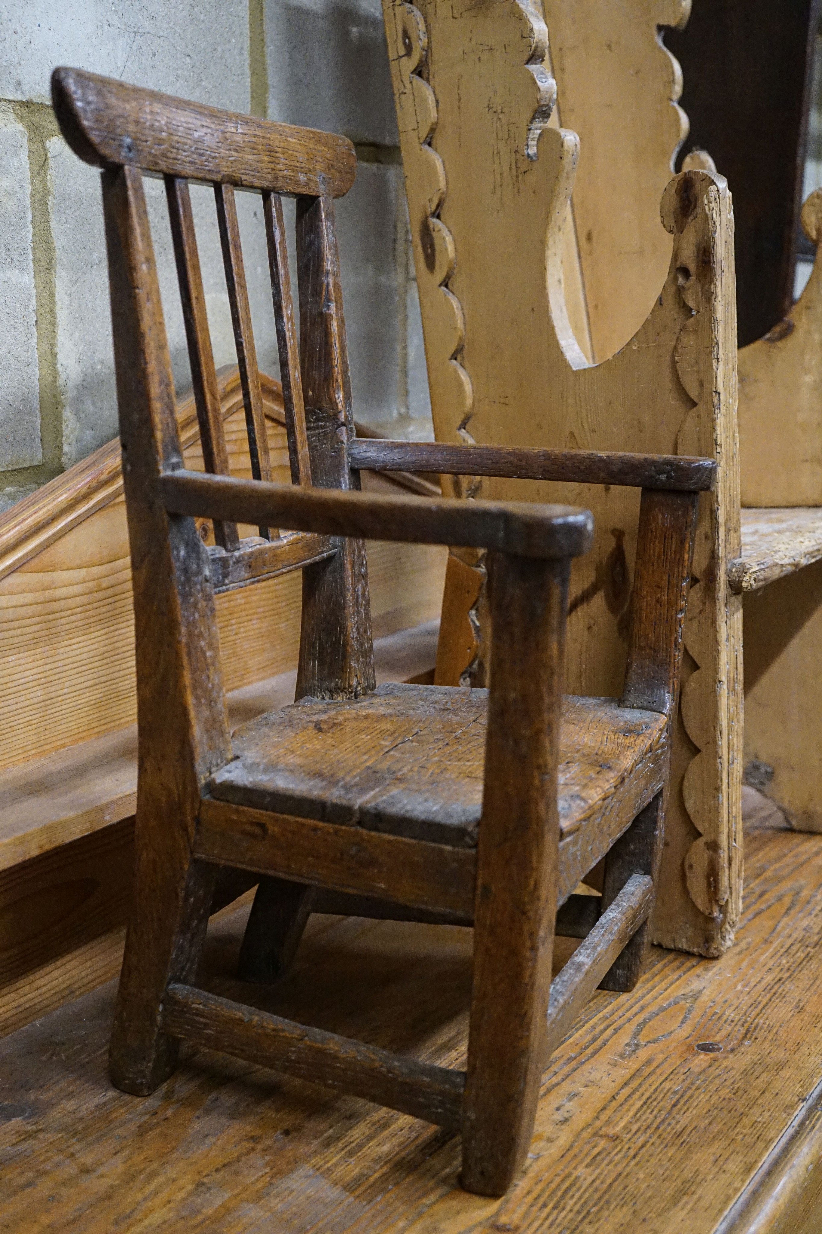 An early 19th century primitive oak child's chair with solid seat, width 39cm height 56cm and a carved pine child's chair, height 78cm